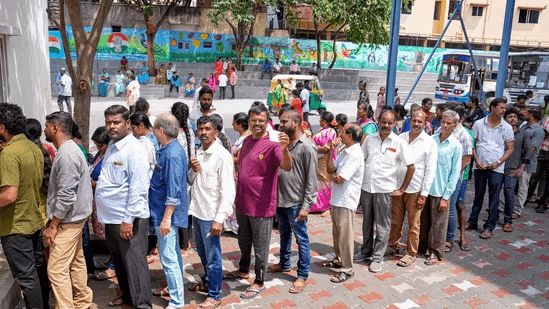Karnataka polls: People wait in queues at a polling station to cast their votes for Karnataka Assembly elections, in Bengaluru. (PTI)