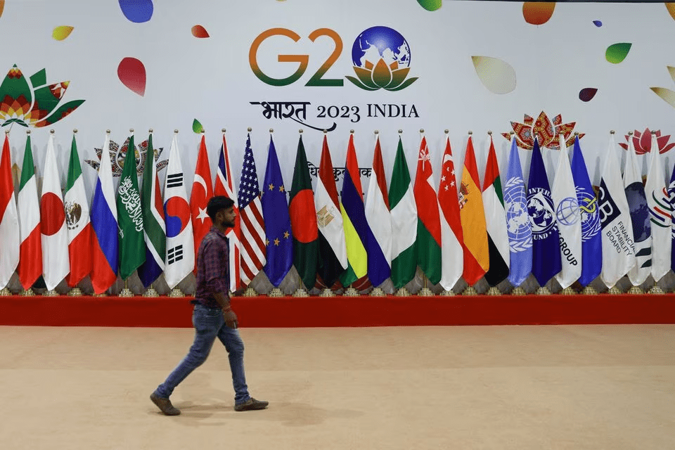 A man walks near flags ahead of G20 Summit in New Delhi, India, September 8, 2023. REUTERS/Anushree Fadnavis